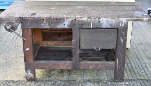 A vintage wooden work bench, with metal vice to front,