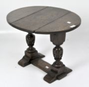 A Victorian small drop leaf table, of oval form, turned supports with a single stretcher,