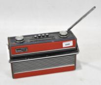 A vintage Roberts radio, R24 AM-F, in a red leatherette and black case.