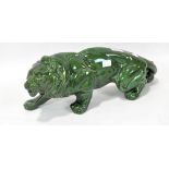 A ceramic model of a hunting lion, glazed in green, length 447cm.