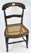 Al late 19th/early 20th century carved wooden child's chair, with seven spreaders, bergere seat,