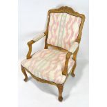 A 20th century carved wooden open armchair, with an arched top,