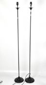 A pair of contemporary cast metal standing lamps, on circular bases,