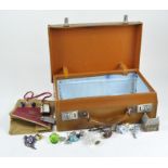 A vintage leather briefcase containing a selection of costume jewellery