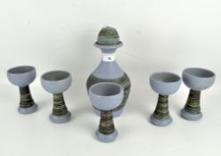 A set of five studio pottery goblets and a flask, glazed in blue with textured handles,
