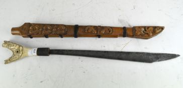 An Asian machete with carved horn handle and wooden scabbard,