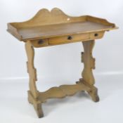 A late 19th-early 20th century pine wash stand, shaped back above a single drawer,
