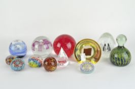 Eleven glass paperweights, some of Italian design, of assorted colours and sizes,