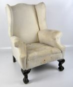 A 19th century wing armchair, with padded back, scroll wings and arms, unupholstered,