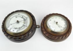 Two vintage aneroid barometers encased in carved wooden mounts,