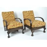 Two 20th century armchairs, with curved wooden arms and claw feet,