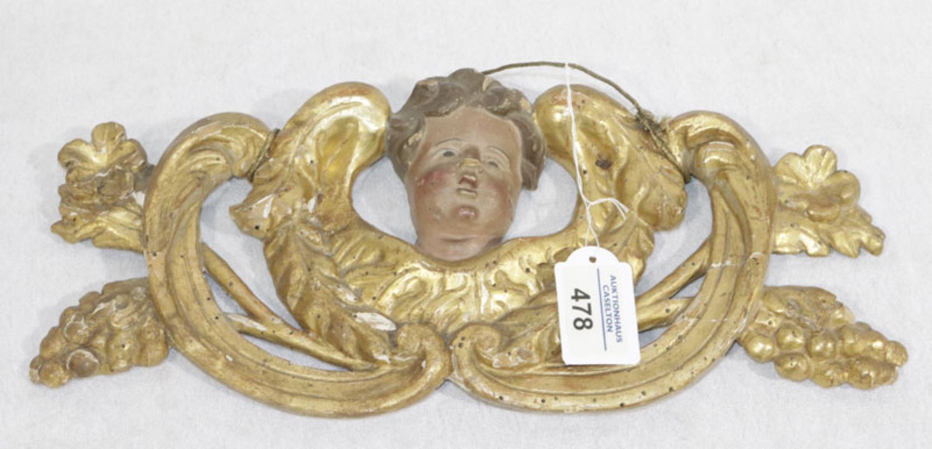 Holz Reliefschnitzerei mit Puttenkopf, farbig/gold gefaßt, Fassung stark beschädigt, H 15 cm, B 36 c
