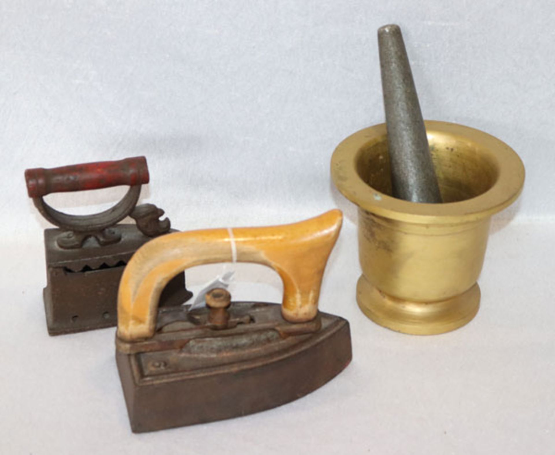 Konvolut: Metall Mörser mit Stößel, H 12 cm, D 14 cm, und 2 antike Bügeleisen mit Holzgriffen, H 12/