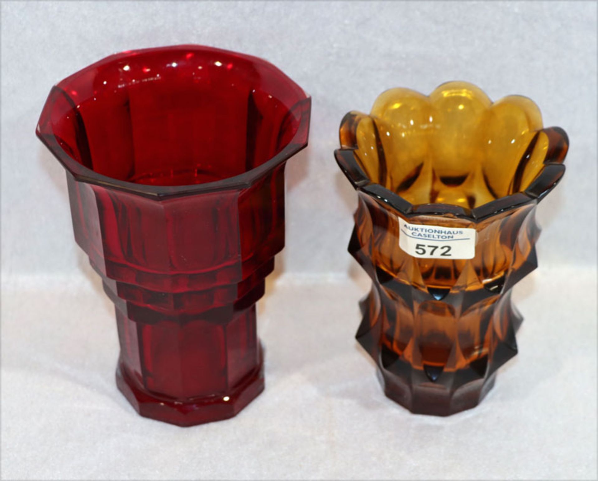2 Glasvasen: rote Glasvase mit Facettenschliff, H 17 cm, D 13 cm, und bernsteinfarbene Vase mit