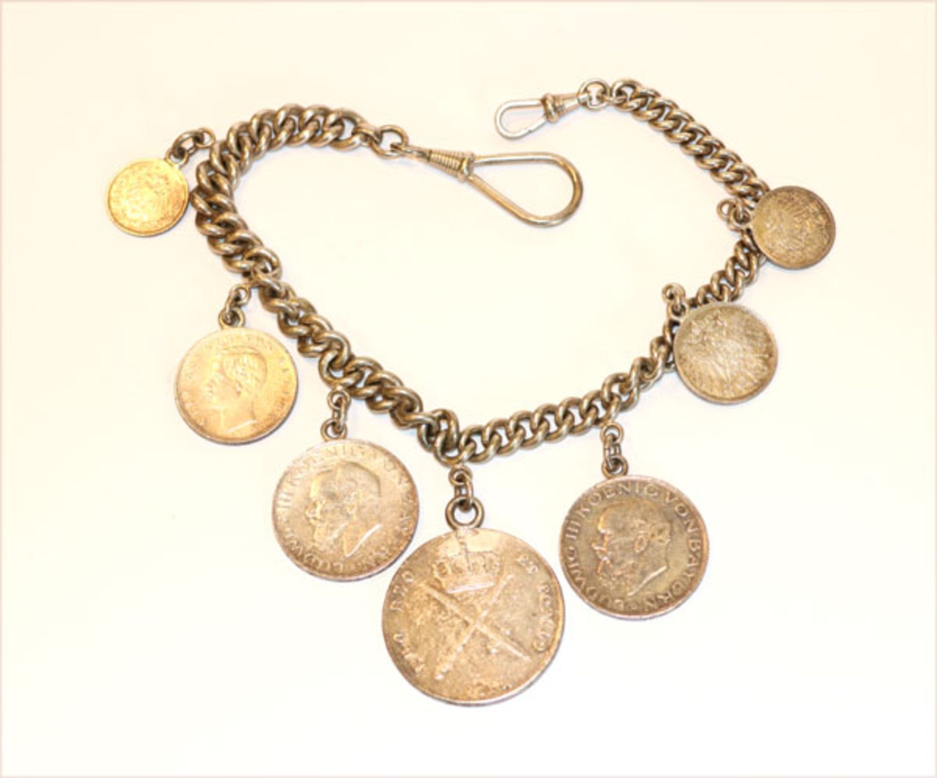 Charivari mit 7 Silbermünzen, zus. 151 gr., an Rundpanzerkette, kein Silber, L 36 cm, Tragespuren