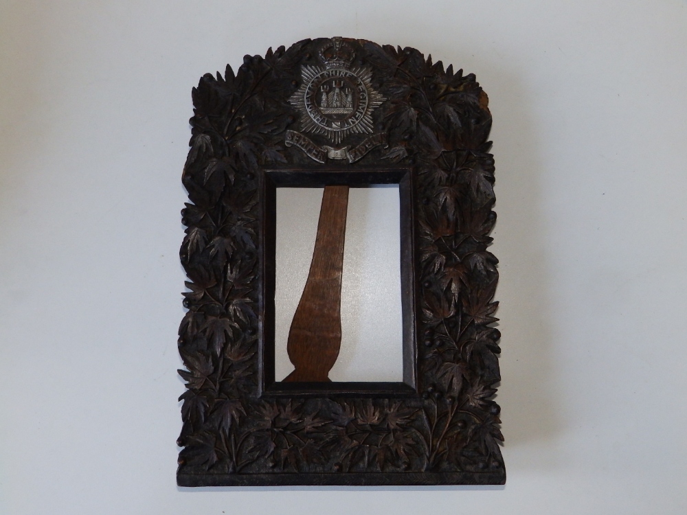 A carved wooden strut photo frame - 'Devonshire Regiment', decorated leaves, 12.25" high.
