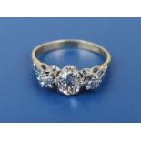 A 'three stone' illusion diamond ring, claw set with a single cushion cut diamond weighing
