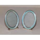 A small pair of enamelled oval Sterling silver photo frames, having pale turquoise guilloche