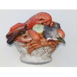 A 20thC continental ceramic study of a basket of seafood, 12" across.