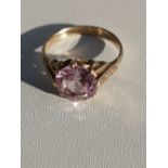 A continental gold ring claw set with a circular cut pink stone. Finger size O/P.