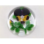 A Baccarat pansy paperweight, decorated in purple, yellow, white & green, with star cut base, 3"