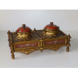 A late 19th/early 20thC Embassy style ormolu double inkstand, with domed enamel hinged covers in