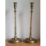 A pair of tall brass tavern candlesticks, the slender knopped stems on dished circular bases, 18"