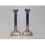 A pair of Edwardian silver Corinthian column candlesticks, with bead edged detachable sconces,