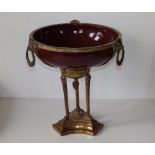A 19thC French Empire style ormolu tazza, fitted with a sang-do-boeuf glazed bowl, the gilt rim