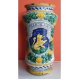 An antique pottery albarello of waisted form, decorated with a heraldic shield surrounded by a