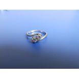 A small two stone diamond crossover set 18ct white gold ring. Finger size L.