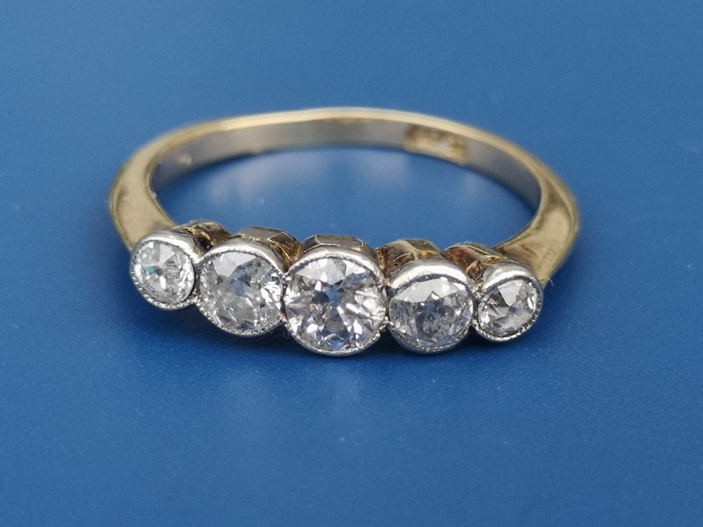 A graduated five stone old cut diamond ring in millegrain settings, the central stone weighing