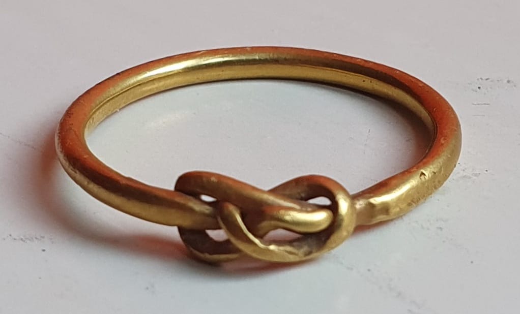 A Tudor gold finger ring, worked with a knot design, 21mm diameter.