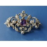 A small Victorian amethyst & diamond brooch, of openwork arabesque scroll form, 1.1" across.