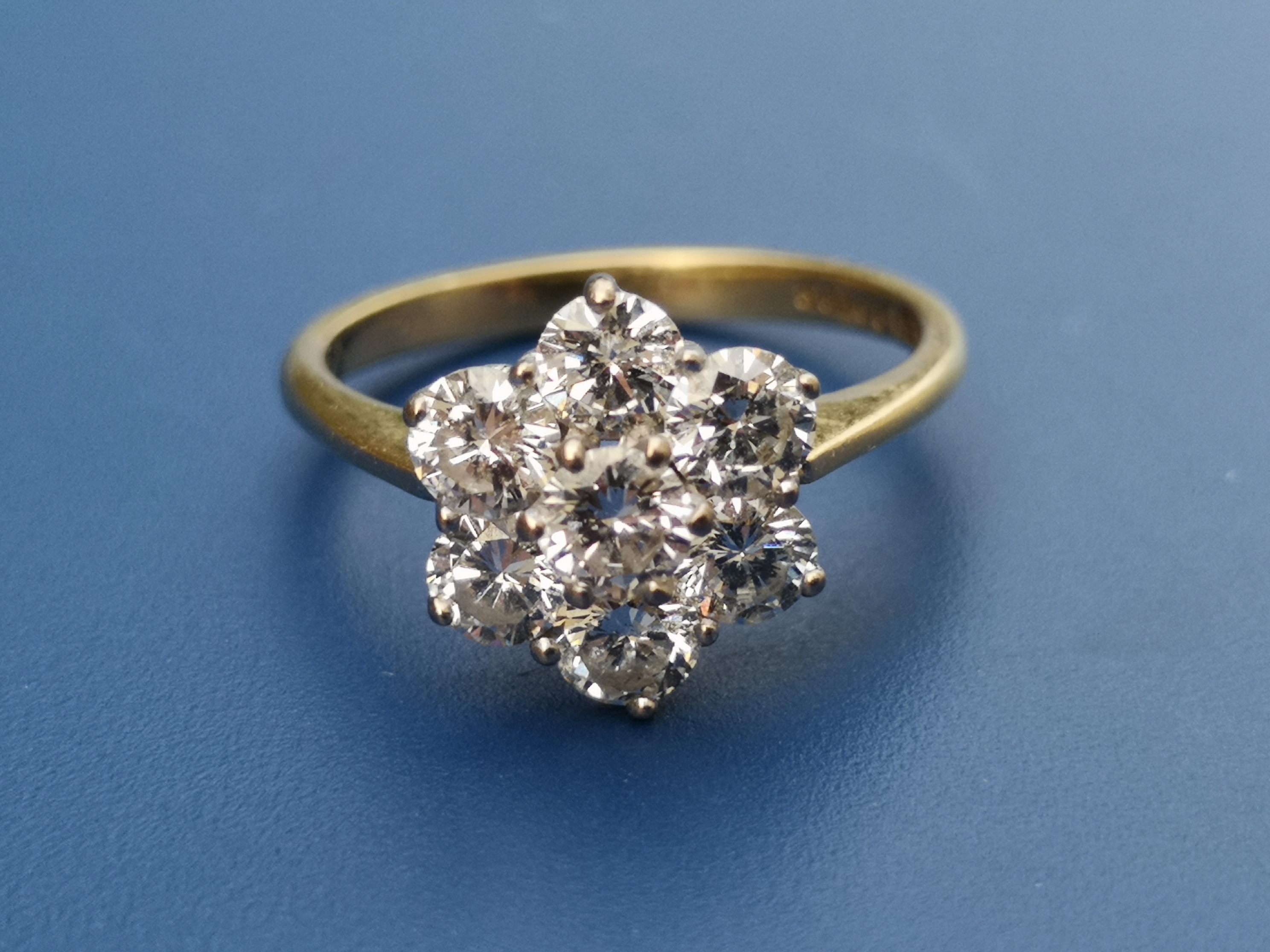 A modern diamond daisy cluster set 18ct gold ring, total diamond weight approximately one carat.