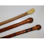 Two Chinese carved bamboo walking canes and a malacca cane with ivorine handle formed as a bear. (