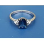 A modern sapphire & diamond set 18ct gold ring, the oval sapphire fanked by six small diamonds - '