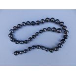 A necklace of black Tahitian 'circle' pearls, having concealed 750 white metal fastener, maximum