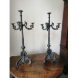 A pair of 19thC cast iron floor-standing triple branch candelabra in the baroque taste, 44" high.