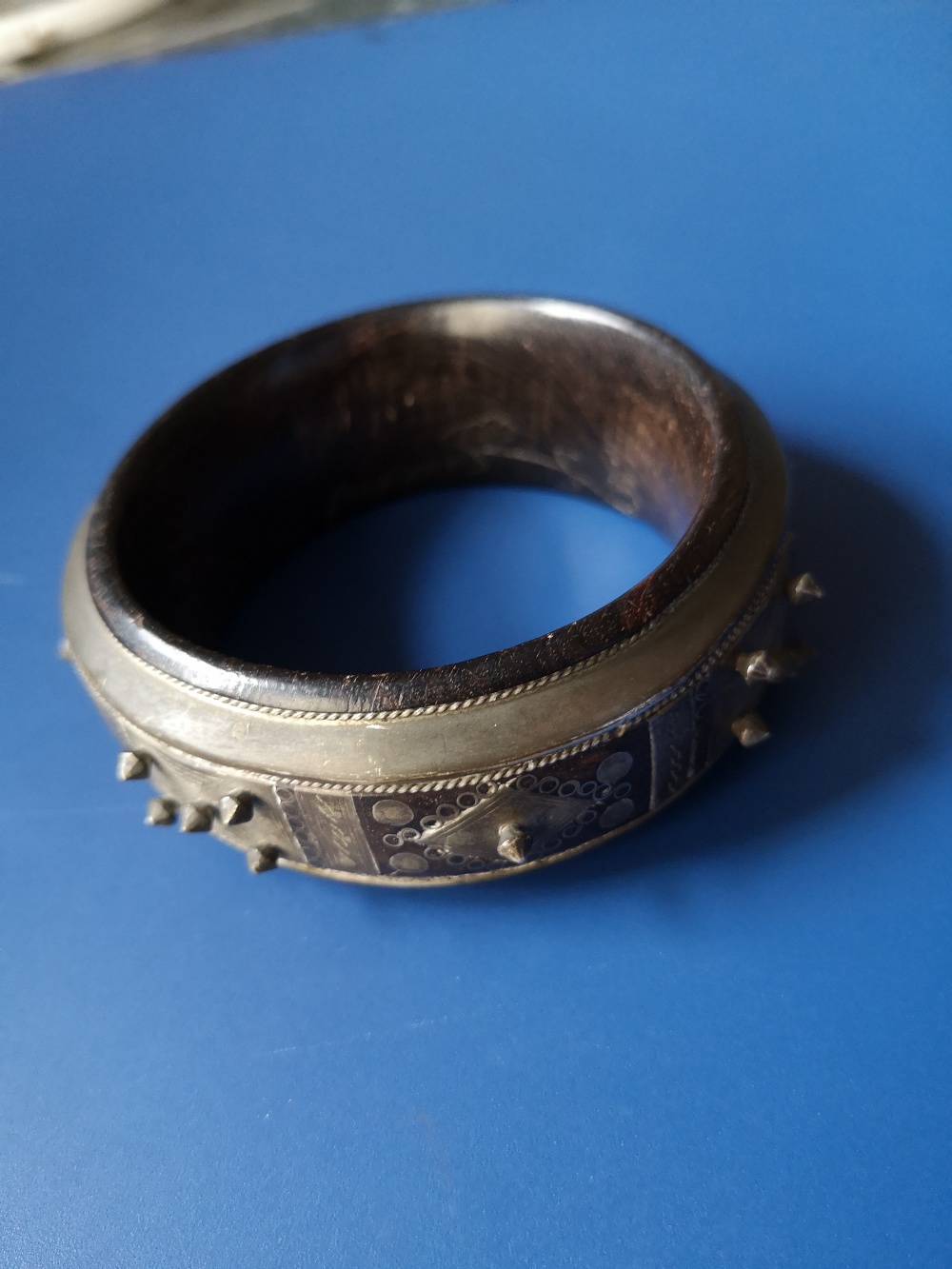 An antique lignum vitae bangle inlaid and applied with silver decoration and studding, , 3.1"