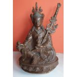 A Sino-Tibetan copper figure of a seated deity with silver inlaid decoration, 8" high.