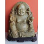 A Chinese carved green stone Buddha, 9" high.