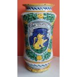 An antique pottery albarello of waisted form, decorated with a heraldic shield surrounded by a