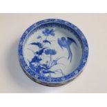 A thickly potted Chinese blue & white porcelain bowl, decorated to centre with a bird hovering above