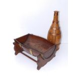 A coopered wooden wine bottle, 11" and a barrel cradle.
