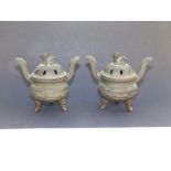 A small pair of Chinese bronze covered censers, each having a Dog of Fo finial, high curved