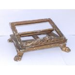A 19thC giltwood bible stand, of low rectangular form on four paw feet - believed to have originated