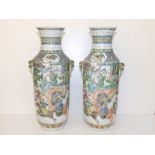 A pair of Chinese famille verte porcelain vases, of rouleau shape with mask handles, decorated