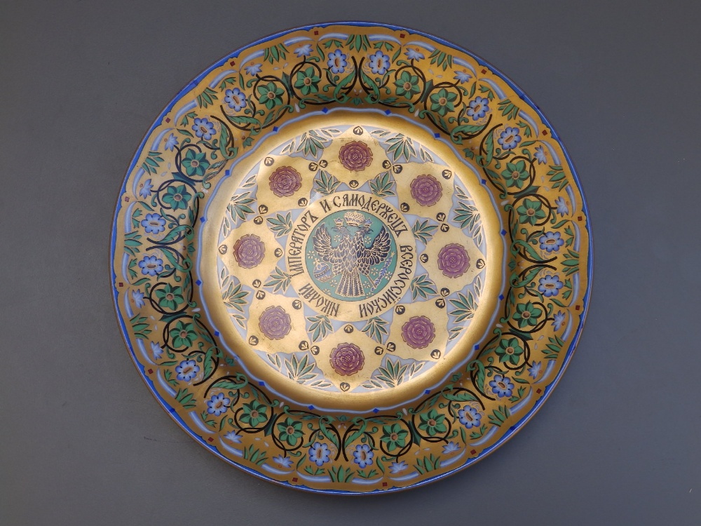 A Russian porcelain gilded plate, decorated to the centre with the double-headed Imperial Eagle