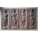 A set of four early oak carved figures of the Apostles, modelled in high relief against round arch